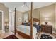 Bedroom featuring a four-poster bed, hardwood floors, and neutral color palette at 3837 Camino Real, Sarasota, FL 34239