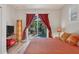 Comfortable bedroom featuring wood floors and glass doors leading to a private outdoor pool area at 3837 Camino Real, Sarasota, FL 34239
