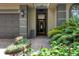 Inviting front entrance featuring lush landscaping, a tiled walkway, and a stylish front door at 3837 Camino Real, Sarasota, FL 34239