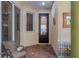 Inviting front entry with decorative door, brick floor, and seating area at 3837 Camino Real, Sarasota, FL 34239