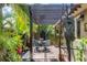Relaxing outdoor patio with pergola, brick pavers, and lush tropical landscaping provides a serene ambiance at 3837 Camino Real, Sarasota, FL 34239