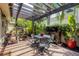Charming outdoor patio with pergola, brick pavers, and garden decor offers a relaxing retreat at 3837 Camino Real, Sarasota, FL 34239