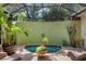 Enclosed pool area with screen, brick pavers, lush potted plants, seating and accent wall decor at 3837 Camino Real, Sarasota, FL 34239