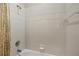 Shower space featuring neutral ceramic tile and updated shower head fixture at 3837 Camino Real, Sarasota, FL 34239