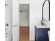 Bright bathroom with a navy vanity, modern fixtures, and view into the next room at 3975 Coleridge Pl, Sarasota, FL 34241