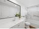 Bathroom features a wide mirror, granite countertops, and marble tiled walls around the tub at 3975 Coleridge Pl, Sarasota, FL 34241