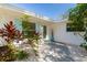 Inviting front entrance with colorful plants and turquoise accents, enhancing the home's charm at 3975 Coleridge Pl, Sarasota, FL 34241