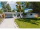 Charming single-story home with well-manicured lawn, white gravel drive, and carport showcasing curb appeal at 3975 Coleridge Pl, Sarasota, FL 34241