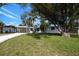 Charming home with a well-manicured lawn, mature trees, and a gravel driveway at 3975 Coleridge Pl, Sarasota, FL 34241
