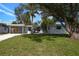 Charming home with a well-manicured lawn, mature trees, and a gravel driveway at 3975 Coleridge Pl, Sarasota, FL 34241