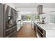 Modern kitchen with stainless steel appliances, white cabinets, and a view of the pool at 3975 Coleridge Pl, Sarasota, FL 34241