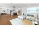 Open-concept living room showcasing wood floors and an adjacent, bright kitchen and dining area at 3975 Coleridge Pl, Sarasota, FL 34241