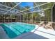 Serene screened-in pool with lounge chairs and clear water, set in a private backyard oasis at 3975 Coleridge Pl, Sarasota, FL 34241