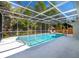 Inviting screened-in pool with clear blue water, surrounded by lush greenery and ample deck space at 3975 Coleridge Pl, Sarasota, FL 34241