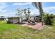 Brick patio with furniture, lounge chairs, and privacy, surrounded by grass at 404 Bayshore Rd, Nokomis, FL 34275