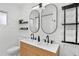 Modern bathroom featuring a double sink vanity with wood paneling, dual mirrors, and minimalist black hardware at 404 Bayshore Rd, Nokomis, FL 34275