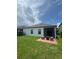 View of the backyard with a small patio, green lawn, and well maintained home at 4077 River Bank Way, Punta Gorda, FL 33980