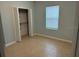 Bedroom featuring tile floors, a window with blinds, and closet space for organized storage at 4077 River Bank Way, Punta Gorda, FL 33980