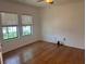 Bright bedroom featuring hardwood floors, two windows, and plenty of natural light at 4077 River Bank Way, Punta Gorda, FL 33980