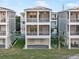 Three-story coastal home with screened balconies, gray siding, and manicured lawn at 4318 Marina View Way, Cortez, FL 34215