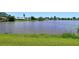 Scenic backyard view showcasing a tranquil pond surrounded by vibrant green grass at 4484 Tortoise Rd, Venice, FL 34293
