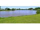Expansive backyard view featuring a large pond, lush green grass, and mature trees along the shoreline at 4484 Tortoise Rd, Venice, FL 34293