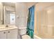 Well-lit bathroom featuring a sink, toilet, and shower with a blue patterned curtain at 4484 Tortoise Rd, Venice, FL 34293