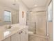 Bright bathroom featuring a white vanity, toilet, and a glass-enclosed shower at 4484 Tortoise Rd, Venice, FL 34293