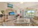 Inviting living room with tile floors, decor, and a view of the lanai and lake beyond at 4484 Tortoise Rd, Venice, FL 34293