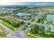 Community aerial view featuring a clubhouse, tennis courts, pool, lush green spaces, and waterways creating an inviting neighborhood at 4625 Canoe Creek Ave, Parrish, FL 34219