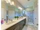Bathroom featuring double sinks, large shower with glass door, and modern finishes at 4625 Canoe Creek Ave, Parrish, FL 34219