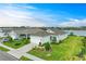 Inviting single-story home featuring lush landscaping, a two-car garage, and a tranquil lake view at 4625 Canoe Creek Ave, Parrish, FL 34219