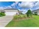 Attractive home featuring a two-car garage, well-kept lawn, and ornamental grasses at 4625 Canoe Creek Ave, Parrish, FL 34219