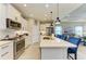 Modern kitchen featuring white cabinets, stainless steel appliances, and a large island with comfortable seating at 4625 Canoe Creek Ave, Parrish, FL 34219