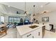 Open-concept kitchen with island, stainless steel appliances, and breakfast bar seating flowing into the living room at 4625 Canoe Creek Ave, Parrish, FL 34219