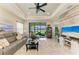 Bright and airy living room with tray ceiling, large windows showcasing water views, and a modern ceiling fan at 4625 Canoe Creek Ave, Parrish, FL 34219