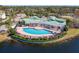Aerial view of community pool, clubhouse, and surrounding lush landscaping and lake at 4802 51St W St # 808, Bradenton, FL 34210