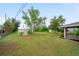 Sprawling backyard with storage shed, screened patio, and mature trees at 496 Fletcher St, Port Charlotte, FL 33954