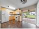 Efficient kitchen with stainless steel appliances, light wood cabinetry, and access to a covered patio for outdoor dining at 496 Fletcher St, Port Charlotte, FL 33954