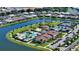 Gorgeous aerial view of a community with a lake, tennis courts, a luxurious pool area, and well-manicured landscaping at 5187 Barnett Cir, Lakewood Ranch, FL 34211