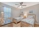 Bedroom with twin beds, wood furniture, coastal decor, ceiling fan, and window at 5187 Barnett Cir, Lakewood Ranch, FL 34211