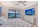 Comfortable bedroom with large window views, ceiling fan, and dresser with mounted TV at 5187 Barnett Cir, Lakewood Ranch, FL 34211