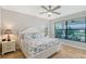 Bright bedroom featuring a ceiling fan, large windows and two nightstands with lamps at 5187 Barnett Cir, Lakewood Ranch, FL 34211