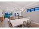 Open-concept dining room with modern light fixture and views of the kitchen and backyard at 5187 Barnett Cir, Bradenton, FL 34211