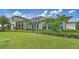 Beautiful clubhouse exterior surrounded by lush landscaping, manicured lawns, and vibrant flowers on a sunny day at 5187 Barnett Cir, Lakewood Ranch, FL 34211