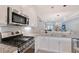 Close up of a kitchen with stainless steel appliances and white cabinets with view to the living area at 5187 Barnett Cir, Lakewood Ranch, FL 34211