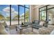 Living room with large windows overlooking pool area and beautiful palm trees with lots of natural light at 5187 Barnett Cir, Lakewood Ranch, FL 34211