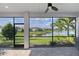 Screened patio featuring scenic lake view, ceiling fan, and brick flooring, perfect for outdoor relaxation at 5187 Barnett Cir, Lakewood Ranch, FL 34211