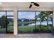 Screened-in patio with serene lake view at dusk, ceiling fan, and stylish brick flooring at 5187 Barnett Cir, Lakewood Ranch, FL 34211