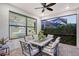 Cozy screened-in patio featuring a dining table, chairs, and a view into the main bedroom through a large window at 5187 Barnett Cir, Lakewood Ranch, FL 34211